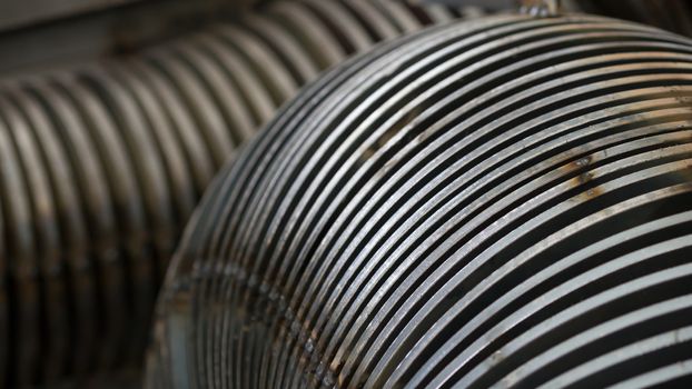 Close-up of steel parts for screw conveyors at an early production stage. Very shallow depth of field.