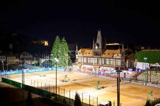 Brasov, Romania - July 24, 2013: Olimpia building by Paul Brang architect with tennis courts in front illuminated at night, Brasov, Romania