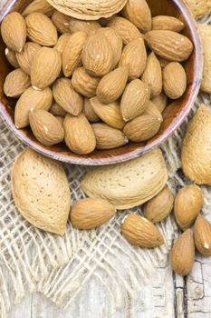 almonds in a bowl on old wooden background