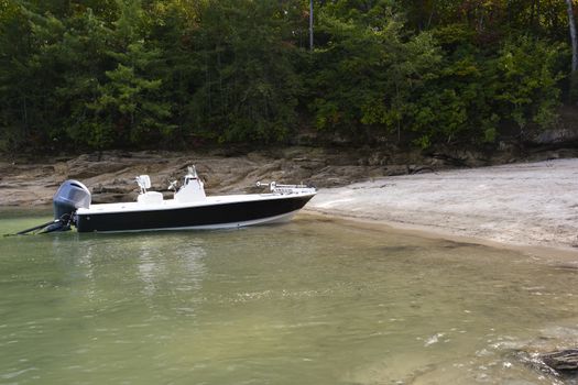 Fishing boat on the shore by a lake.