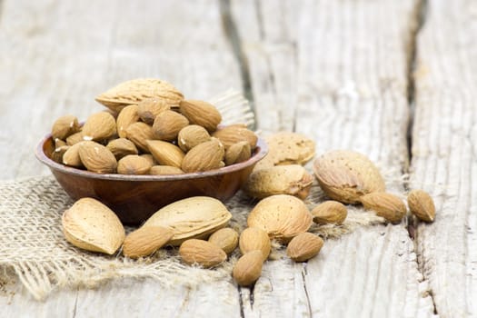 almonds in a bowl on old wooden background