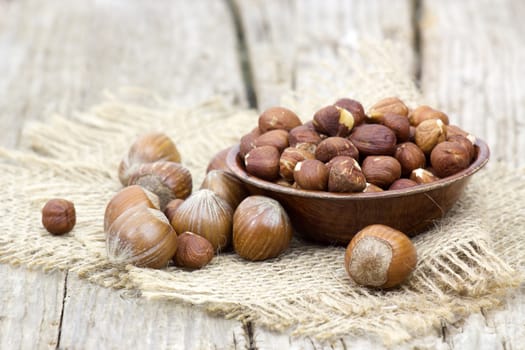 hazelnuts in a bowl on old wooden background