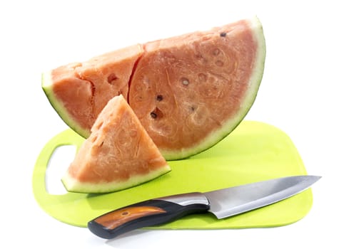 Slices of watermelon on green plastic board with knife.