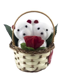 A cute white teddy bears with with rose in basket.
