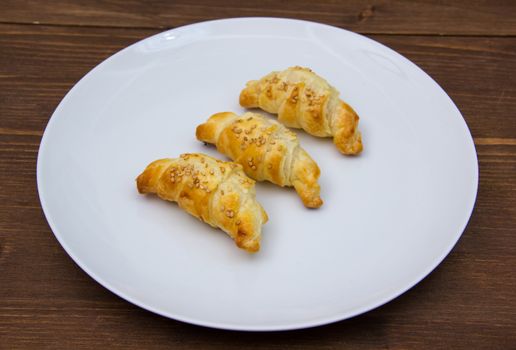 Savory croissants with sesame on wooden table