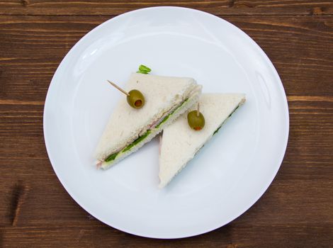 Triangular sandwiches on wooden table seen from above