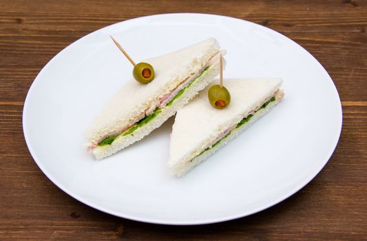 Triangular sandwiches on plate on wooden table