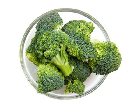 Broccoli in glass bowl on a white background seen from above