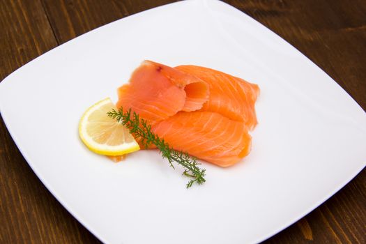 Smoked salmon on plate on wooden table