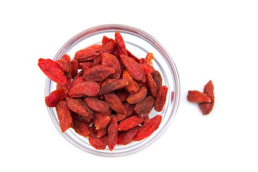 Goji berries on bowl on white background viewed from above