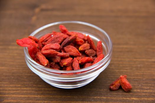 Goji berries in bowl on wooden table