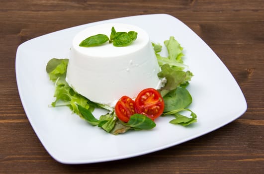 Cottage cheese on the plate on wooden table