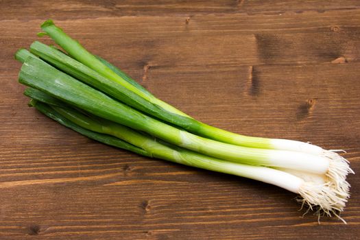 Spring onion on wooden table seen close