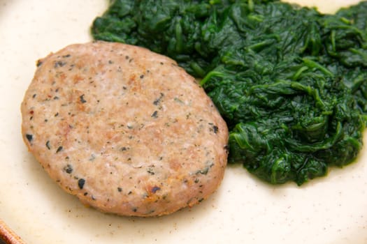 Hamburger meat with boiled spinach seen close
