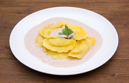 Ravioli with radicchio sauce on wooden table