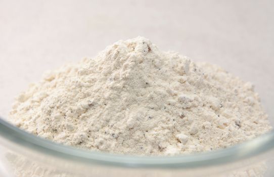 Close-up of malted, mixed seed bread flour mix in a glass bowl