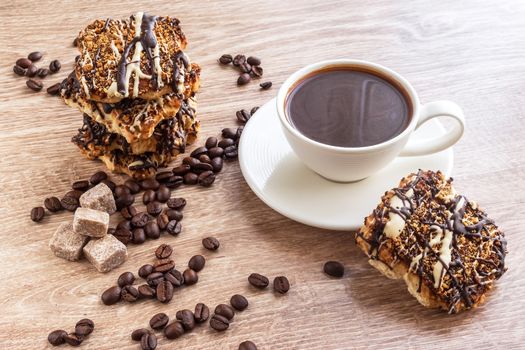 Black coffee in white cup and cookies with frosting