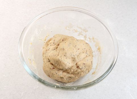 Freshly kneaded bread dough in a glass bowl on a kitchen work surface