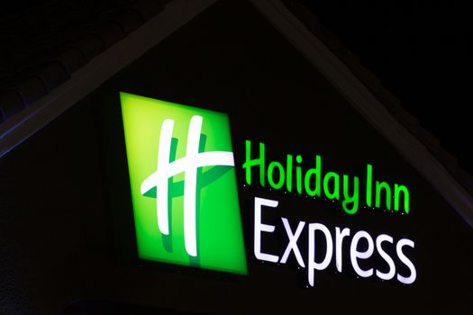 LANCASTER, CA/USA - APRIL 19, 2014: Holiday Inn Express Sign at night. Holiday Inn Express is a mid-priced hotel chain branded by InterContinental Hotels Group.