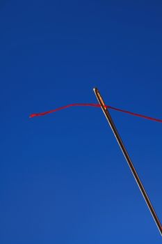 macro image of needle and red thread against colorful background