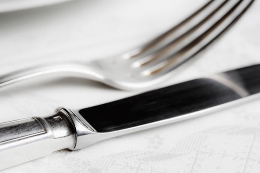 elegant table setting with silverware on white cloth