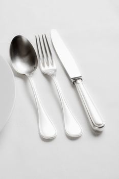 elegant table setting with silverware on white cloth