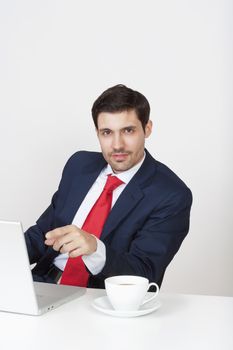 young business executive in suit behind desk with laptop