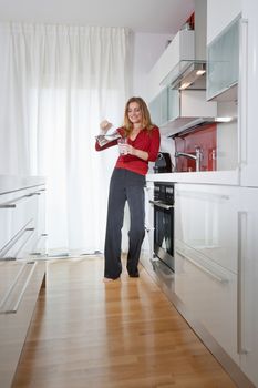 young beautiful woman standing in modern kitchen interior