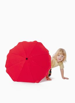 boy with long blond hair playing with a red umbrella - clipping path