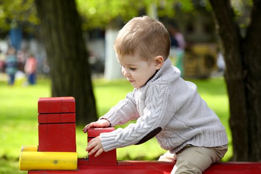 2 years old Baby boy on playground in spring outdoor park 