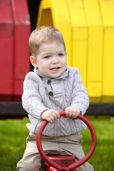 2 years old Baby boy on playground in spring outdoor park 