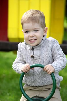 2 years old Baby boy on playground in spring outdoor park 