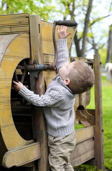 2 years old curious Baby boy managing with old agricultural Machinery