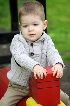 2 years old Baby boy on playground in spring outdoor park 