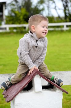 2 years old baby boy sitting on the little rooftop