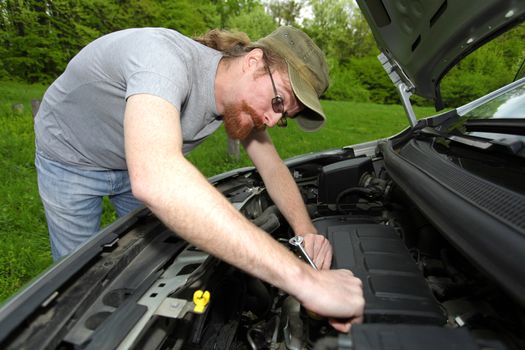 mechanic repairs a car on the road