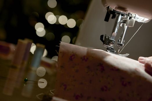 Low key detail of automatic sewing machine needle shot from the side