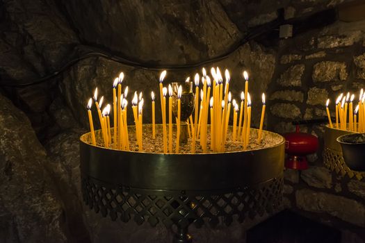 Burning Candles inside a stoned chapel