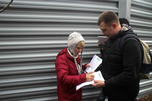 Krasnodar region, Russia - March 23, 2012. The ecologist Evgenia Chirikova and the politician Nikolay Lyaskin near a fence of a cottage of the governor Tkachyov in the protected wood