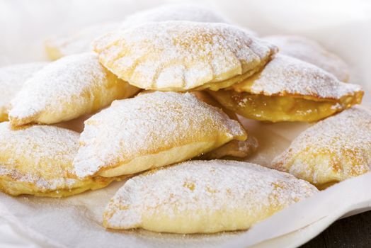 Close up Delicious Cookies with Sugar on Plate with White Paper, Placed on Wooden Table.