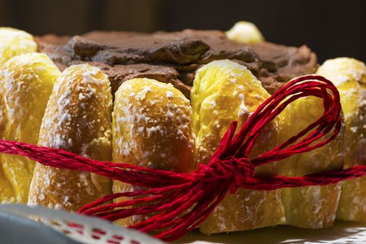 Chocolate cake decorated around the side with freshly baked crispy pastries and glazed with rich chocolate icing