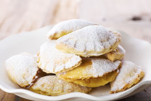 Close up Delicious Cookies with Sugar on Plate with White Paper, Placed on Wooden Table.