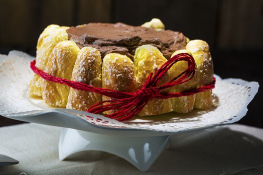 Chocolate cake decorated around the side with freshly baked crispy pastries and glazed with rich chocolate icing