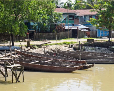 Wooden boats along the riverside in Mrauk U, Western Rakhin State, Myanmar.