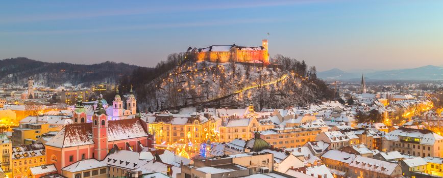 Aerial panoramic view of Ljubljana decorated for Christmas holidays. Roofs covered in snow in winter time. Slovenia, Europe.