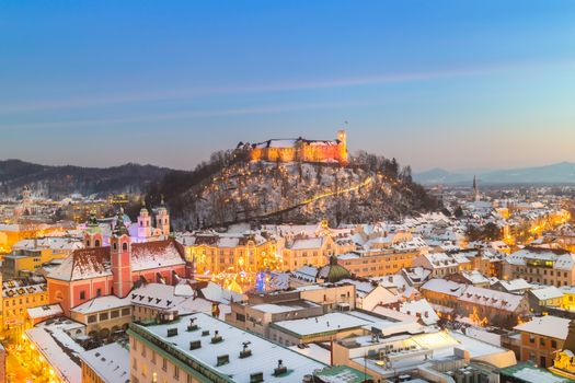 Aerial panoramic view of Ljubljana decorated for Christmas holidays. Roofs covered in snow in winter time. Slovenia, Europe.
