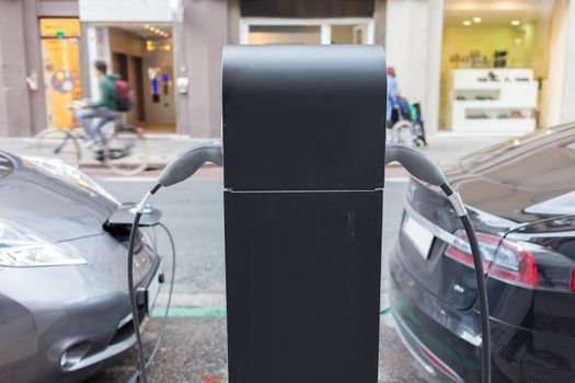 Power supply for electric car charging.  Electric cars charging station. Power supply plugged into an electric car being charged.