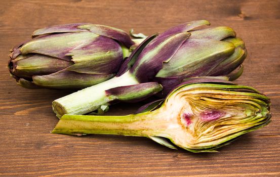 Artichoke cut in half on wooden table