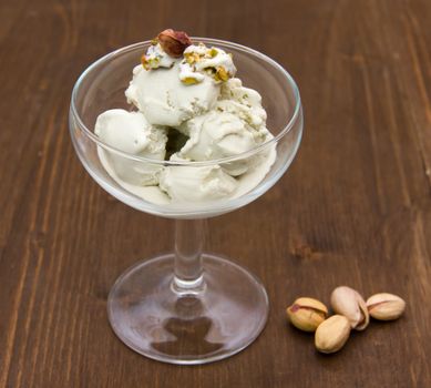 Cup with pistachio ice cream on wooden table