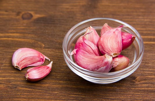 Garlic in glass bowl on wooden table